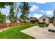 Large backyard features a concrete patio, green lawn, tall trees and a privacy fence at 5101 E 122Nd Cir, Thornton, CO 80241