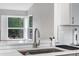 Close-up of a modern kitchen sink with white countertops and a large window at 5101 E 122Nd Cir, Thornton, CO 80241