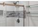 Close-up of the shower with grey accent tiles, a shower head and glass doors at 5101 E 122Nd Cir, Thornton, CO 80241