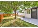 View of the backyard with a concrete patio area and mature tree at 5147 Saint Paul St, Denver, CO 80216