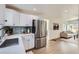 Contemporary kitchen with stainless steel refrigerator and an open view to the living room at 5147 Saint Paul St, Denver, CO 80216