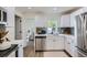 Bright kitchen features white cabinets, stainless appliances, and view into adjacent bathroom at 5147 Saint Paul St, Denver, CO 80216