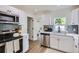 Bright kitchen with white cabinetry, stainless steel appliances, and a view into the bathroom at 5147 Saint Paul St, Denver, CO 80216
