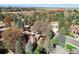A scenic aerial view shows a home with mature trees and landscaping at 10886 E Crestline Cir, Englewood, CO 80111