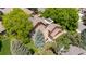 Beautiful aerial view of a home with a stone chimney surrounded by lush trees and green lawns at 10886 E Crestline Cir, Englewood, CO 80111