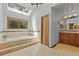 Bright bathroom featuring a skylight, soaking tub, and tiled flooring, with natural light streaming in at 10886 E Crestline Cir, Englewood, CO 80111