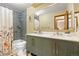 Stylish bathroom boasts a dual sink vanity with a decorative shower featuring grey tiling at 10886 E Crestline Cir, Englewood, CO 80111