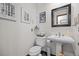 Cozy powder room featuring a pedestal sink and a decorative mirror at 10886 E Crestline Cir, Englewood, CO 80111