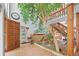 Bright foyer featuring a hardwood floor, large indoor tree, and a staircase at 10886 E Crestline Cir, Englewood, CO 80111
