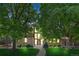 Inviting brick home boasts a striking front facade with large windows and mature trees at 10886 E Crestline Cir, Englewood, CO 80111