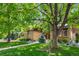 Charming single-story brick home featuring mature trees and lush landscaping at 10886 E Crestline Cir, Englewood, CO 80111
