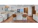 Modern kitchen with white cabinets, stainless steel appliances, granite countertops, and an island with seating at 10886 E Crestline Cir, Englewood, CO 80111