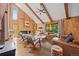 Cozy living room with vaulted ceilings, wood paneling, brick fireplace, and comfortable leather furniture at 10886 E Crestline Cir, Englewood, CO 80111