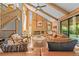 Sunlit living room boasts a brick fireplace, wood paneling, and comfortable leather furniture at 10886 E Crestline Cir, Englewood, CO 80111