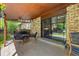 Covered patio with stylish outdoor seating, brick accents, and a view of the lush backyard at 10886 E Crestline Cir, Englewood, CO 80111