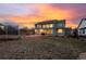 Backyard with a large two-story home with large windows, patio, and a trampoline under a colorful evening sky at 3685 Roberts St, Mead, CO 80542