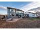 Two-story backyard with stone patio, fire pit, with large windows and landscaped yard at 3685 Roberts St, Mead, CO 80542