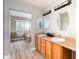 Bright bathroom featuring double sinks, wood cabinets, and a separate tub area for a luxurious feel at 3685 Roberts St, Mead, CO 80542
