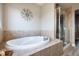 Modern bathroom featuring a luxurious tub, tiled walls, and a glass-enclosed shower for a spa-like experience at 3685 Roberts St, Mead, CO 80542