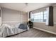 Cozy bedroom showcasing a large window, a vanity, and neutral colored walls with white trim at 3685 Roberts St, Mead, CO 80542
