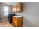 A well-appointed laundry room with wooden cabinets, stainless steel appliances, and a sink for added convenience at 3685 Roberts St, Mead, CO 80542