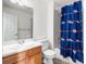 Bathroom featuring a blue Broncos-themed shower curtain, vanity, and tiled shower at 3000 E 112Th Ave # 86, Northglenn, CO 80233