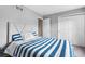 Comfortable bedroom with a striped blue and white comforter and a neutral-toned padded headboard at 3000 E 112Th Ave # 86, Northglenn, CO 80233