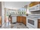 Bright kitchen with white appliances, light wood cabinets, and a view into the dining area at 3000 E 112Th Ave # 86, Northglenn, CO 80233