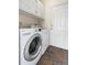 This laundry room features a washer and dryer, upper cabinets, and a door to the exterior at 3000 E 112Th Ave # 86, Northglenn, CO 80233