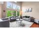 Bright living room with soaring ceilings, large windows, hardwood floors, and modern furnishings at 3000 E 112Th Ave # 86, Northglenn, CO 80233
