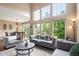 Open-concept living room with soaring ceilings, large windows, hardwood floors, and dining area at 3000 E 112Th Ave # 86, Northglenn, CO 80233
