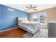 This main bedroom is naturally lit with large windows and features hardwood floors and blue accent wall at 3000 E 112Th Ave # 86, Northglenn, CO 80233
