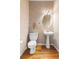 Charming powder room with pedestal sink, oval mirror, decorative lighting, and hardwood floors at 3000 E 112Th Ave # 86, Northglenn, CO 80233