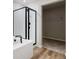 Modern bathroom featuring a bathtub, glass-enclosed shower, and a walk-in closet at 17942 E 94Th Pl, Commerce City, CO 80022