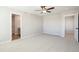 Spacious bedroom with carpet, ceiling fan, and two doorways to other areas of the house at 17942 E 94Th Pl, Commerce City, CO 80022