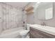 Bathroom with wood cabinet, white marbled tile, floating shelves, and updated fixtures at 9921 Wigham St, Thornton, CO 80229