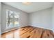 Bedroom with wood floors, light neutral walls, and a bright window with a view of the trees at 9921 Wigham St, Thornton, CO 80229