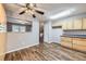 Bright kitchen featuring wood cabinets and hardwood floors, with a view into the adjacent living area at 9921 Wigham St, Thornton, CO 80229