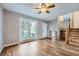 Bright living room showcasing hardwood floors, a large window, and a staircase leading to the upper level at 9921 Wigham St, Thornton, CO 80229