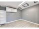 Spacious room with gray walls, light wood-style flooring, and modern recessed lighting at 9921 Wigham St, Thornton, CO 80229