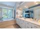 Bright bathroom featuring double sinks, a vanity, a jacuzzi soaking tub, and a fireplace at 7053 S Shawnee St, Aurora, CO 80016