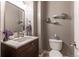 Stylish powder room with a modern vanity, decorative mirror, and floating shelves for an elegant touch at 7053 S Shawnee St, Aurora, CO 80016