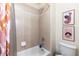 Bathroom featuring a shower and tub combination and neutral colored tiles at 7053 S Shawnee St, Aurora, CO 80016