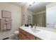 Cozy bathroom featuring a wood vanity, a large mirror, and a shower with glass doors at 7053 S Shawnee St, Aurora, CO 80016