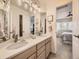 Bright bathroom with a double-sink vanity, modern fixtures and a view into the bedroom at 7053 S Shawnee St, Aurora, CO 80016
