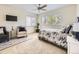 Cozy bedroom featuring a ceiling fan, a large window and comfortable seating area at 7053 S Shawnee St, Aurora, CO 80016