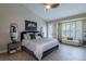 Bright bedroom with neutral decor, including a large bed, stylish mirrors, and a window with plantation shutters at 7053 S Shawnee St, Aurora, CO 80016