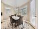 Cozy dining room featuring a marble-top table, pendant lighting, and multiple windows at 7053 S Shawnee St, Aurora, CO 80016