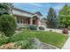 A gorgeous two-story house with a brick facade, well-manicured lawn and attached three-car garage at 7053 S Shawnee St, Aurora, CO 80016