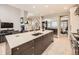 Open kitchen design with a large island, breakfast bar and stainless steel refrigerator at 7053 S Shawnee St, Aurora, CO 80016